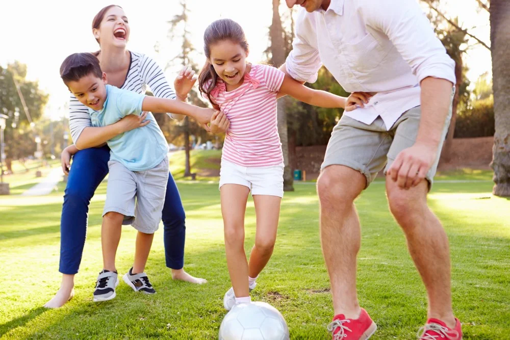 Familie der spiller fodbold i haven